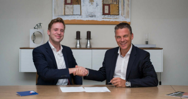 Wietse van der Werf, founder and CEO of Sea Ranger Service shakes hands with Koen van Swam, general manager of the North Sea Farm Foundation, over a signed contract.