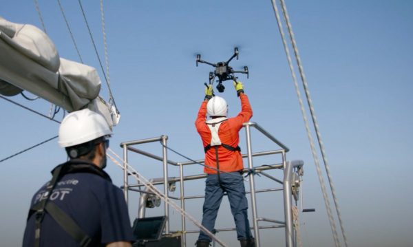 A Sea Ranger on a boat, out at sea, setting up a drone to carry out ocean conservation work.