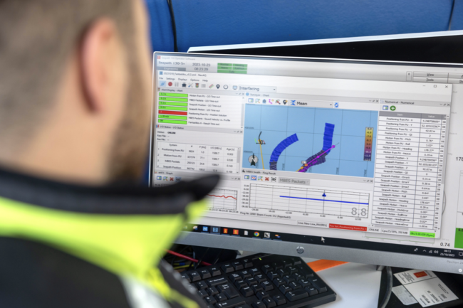 A Sea Ranger sat at a computer looking at ocean data.